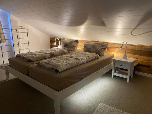a bed in a room with a lamp on a table at Lina's Ferienwohnungen - zwei moderne FeWos mit Sauna im Haus und fantastischem Ausblick in Sankt Andreasberg