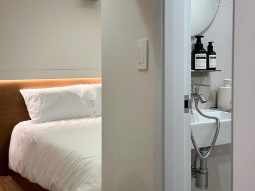 a bedroom with a bed and a sink with a mirror at Gurida Bupyeong in Incheon