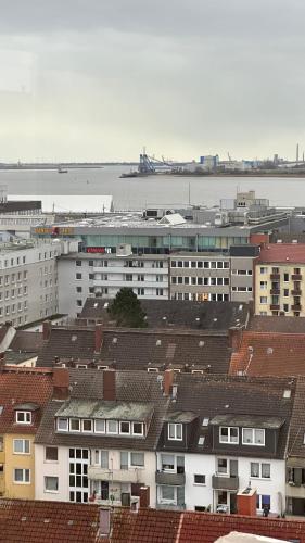a group of buildings with the water in the background at Penthouse Atmosphäre mit Meerblick FeWo am Deich 11 in Bremerhaven