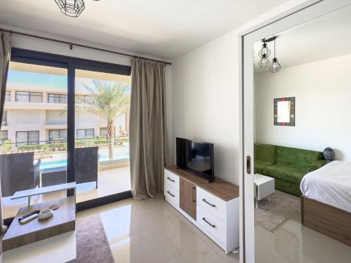 a bedroom with a bed and a tv and a window at El Gouna - BIRD NEST in Hurghada