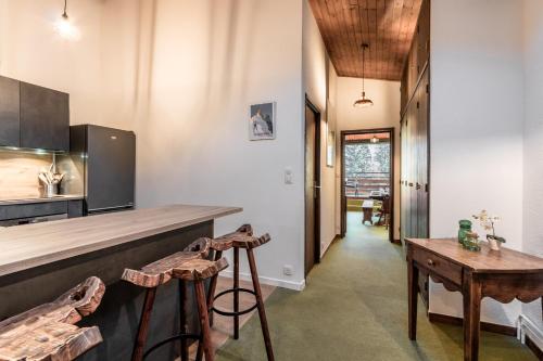 une cuisine avec un comptoir et deux tabourets dans l'établissement Cristal des Glaces - Balcon avec vue imprenable, à Chamonix-Mont-Blanc