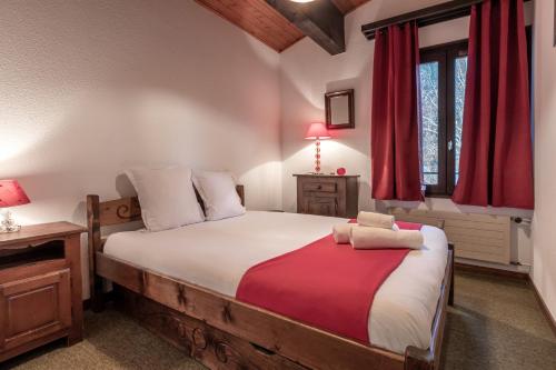 - une chambre avec un grand lit et des rideaux rouges dans l'établissement Cristal des Glaces - Balcon avec vue imprenable, à Chamonix-Mont-Blanc