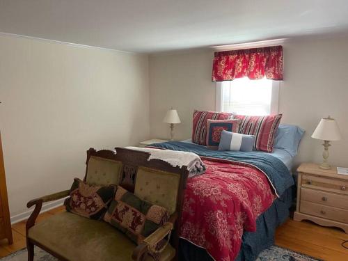 a bedroom with a bed with a red blanket and a window at The Hideaway in Brewster