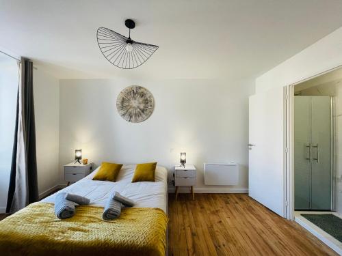 une chambre avec un grand lit et un lustre dans l'établissement Le Numero 1, à Saint-Jean-dʼAngély