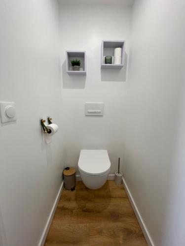 La salle de bains blanche est pourvue de toilettes. dans l'établissement Le Numero 1, à Saint-Jean-dʼAngély