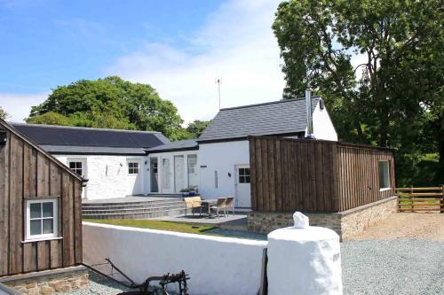 a white house with a fence next to it at The Lambing Shed, Converted Barn nr Little Haven in Haverfordwest