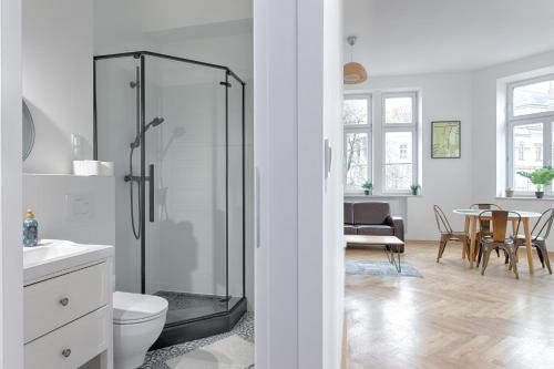 a bathroom with a shower and a dining room at Apartament na Granicy 6 in Cieszyn