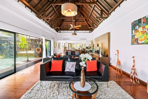 a living room with a black couch and orange pillows at Villa Sea View by IHR in Bel Ombre