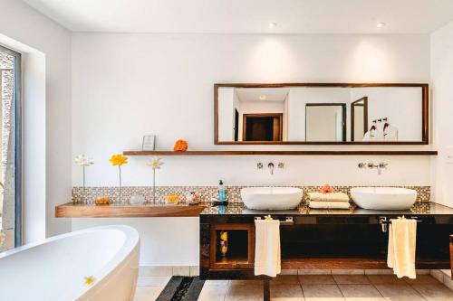 a bathroom with two sinks and a tub and a mirror at Villa Sea View by IHR in Bel Ombre