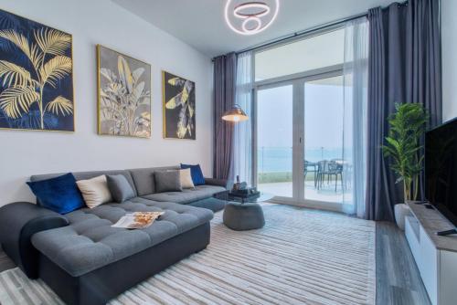 a living room with a couch and a large window at GlobalStay Royal Bay Beachfront Apartments Palm Jumeirah in Dubai