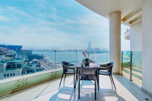 a table and chairs on a balcony with a view of the ocean at GlobalStay Royal Bay Beachfront Apartments Palm Jumeirah in Dubai