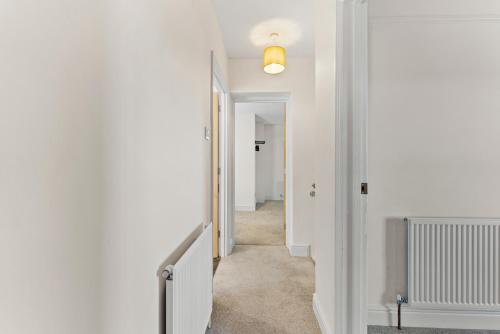 a hallway with white walls and a white stairway at Amazing Rural Retreat in The Cotswolds - Parking in Frome