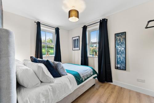 a bedroom with a couch and two windows at Amazing Rural Retreat in The Cotswolds - Parking in Frome