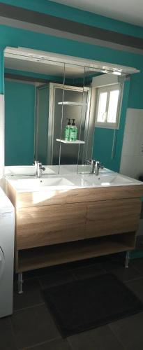 une salle de bain avec deux lavabos et un grand miroir dans l'établissement Villa élégante à Saint Clair-d'Arcey avec piscine privée, à Bernay