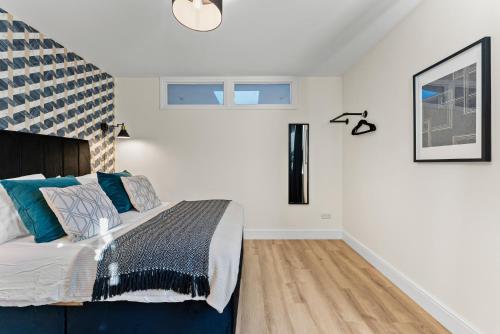 a bedroom with a large bed with blue pillows at Amazing Rural Retreat in The Cotswolds - Parking in Frome