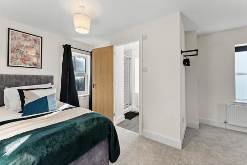 a bedroom with a bed with a green comforter at Amazing Rural Retreat in The Cotswolds - Parking in Frome