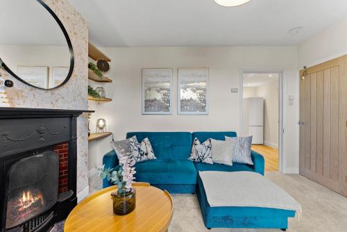 a living room with a blue couch and a fireplace at Amazing Rural Retreat in The Cotswolds - Parking in Frome