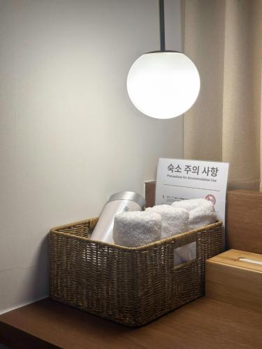 a bathroom with a basket with towels and a light at Gurida Bupyeong in Incheon