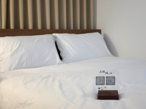 a bed with white pillows with a price tag on it at Gurida Bupyeong in Incheon