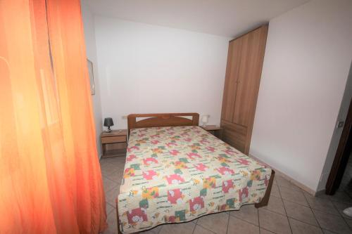a bedroom with a bed with a comforter on it at Lovely 3 room flat in Rosolina with shared pool in Rosolina Mare