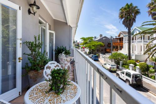 a balcony with a table and chairs and a street at Home for 8 in central Green Point in Cape Town