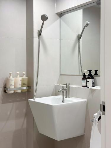 a white bathroom with a sink and a mirror at Gurida Bupyeong in Incheon