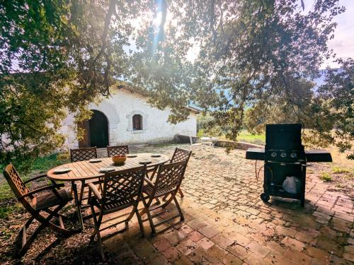 a patio with a table and a stove at CAN QUEL - Escapada a la natura in Les Planes d'Hostoles