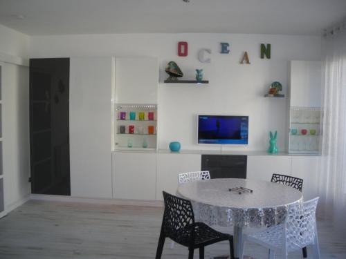une salle à manger avec une table et des chaises et une télévision dans l'établissement PERLE et ÉCUME à L OCEANIC, à Royan