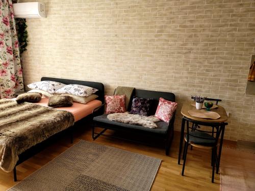 a living room with a couch and a chair at Apartman "CHARLIZE" with PRIVATЕ PARKING in Novi Sad
