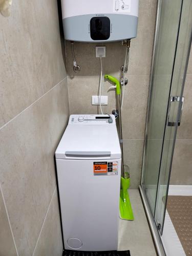 a small refrigerator in a bathroom with a water tank at Apartman "CHARLIZE" with PRIVATЕ PARKING in Novi Sad