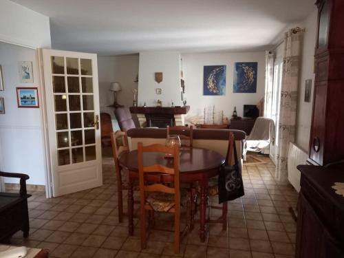 une salle à manger et un salon avec une table et des chaises dans l'établissement maison de famille bord mer doublon, à Sarzeau