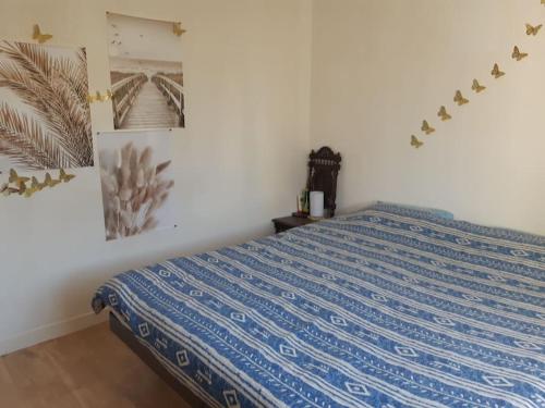 une chambre avec un lit avec une couette bleue dans l'établissement maison de famille bord mer doublon, à Sarzeau