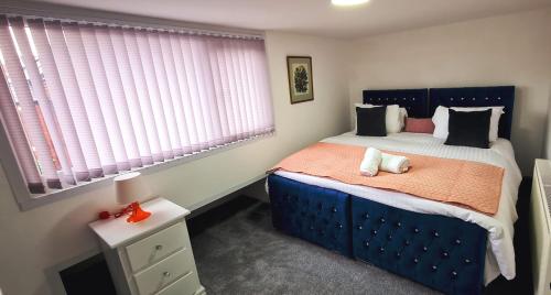 a small bedroom with a blue bed and windows at Large Victorian House 15 minutes from City Centre in Manchester