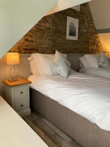 a bed with white sheets and pillows in a bedroom at The Royal Oak, Gladestry in Gladestry
