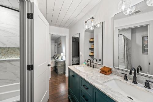 a bathroom with two sinks and two mirrors at River Cottage in Gatlinburg