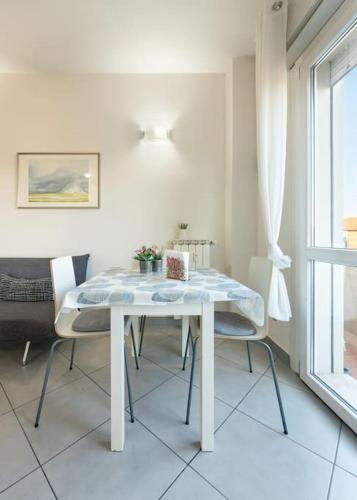 a white table and chairs in a room with a window at Crystal house FRONT TRAMVIA in Florence