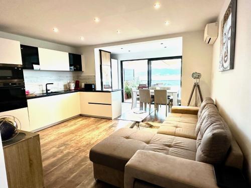 un salon avec un canapé et une cuisine dans l'établissement Appartement Porticcio - Vue sur le golfe - tout confort - idéalement situé, à Grosseto-Prugna