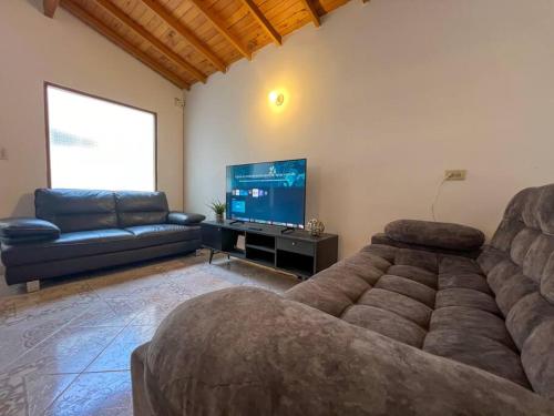a living room with a couch and a flat screen tv at Party house, poblado, Movie Theater, Terrace in Envigado