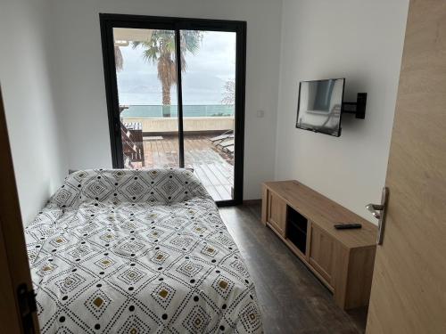 - une chambre avec un lit, une télévision et un balcon dans l'établissement Appartement Porticcio - Vue sur le golfe - tout confort - idéalement situé, à Grosseto-Prugna