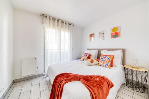 - une chambre blanche avec un lit recouvert d'une couverture orange dans l'établissement Au Cœur de Disneyland, Gare & Shopping à 2 pas, à Chessy