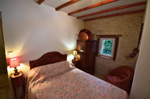 a bedroom with a bed and a window at Maison à Sauvagnas avec piscine - Clévacances 3 clés in Sauvagnas