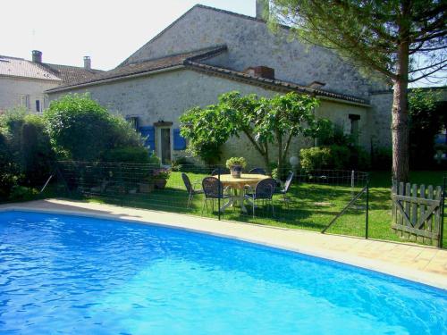 a pool in front of a house with a table and chairs at Maison à Sauvagnas avec piscine - Clévacances 3 clés in Sauvagnas