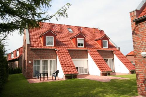 a house with an orange tile roof at Ferienhäuser Greetsiel in Ostfriesland in Greetsiel