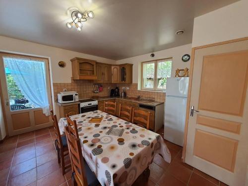 une cuisine avec une table et un réfrigérateur blanc dans l'établissement Maison rénovée à Reaup Lisse - Clévacances 2 Clés, à Lisse