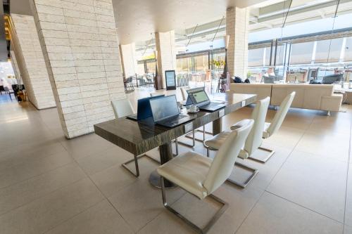 a dining room with a table with laptops and chairs at Terrado Suites Antofagasta in Antofagasta