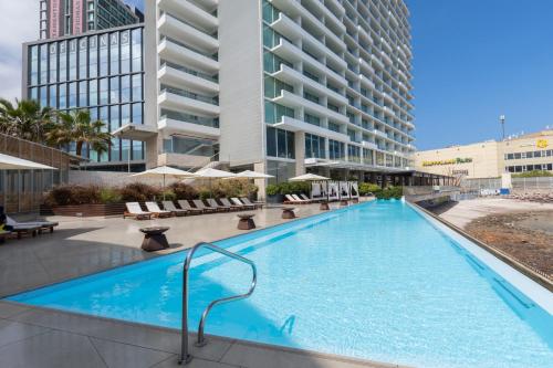 a swimming pool in front of a building at Terrado Suites Antofagasta in Antofagasta