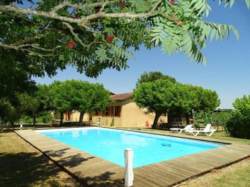 une piscine devant une maison avec des arbres dans l'établissement Maison contemporaine pour 12 personnes, à La Sauvetat-de-Savères