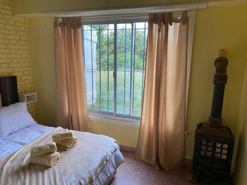 a bedroom with a bed and a large window at Departamento en Miramar in Miramar