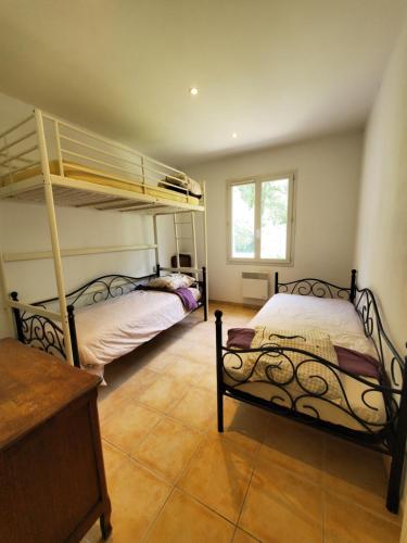 une chambre avec deux lits superposés et une fenêtre dans l'établissement Villa 15 perso, piscine chauffée, au Thoronet