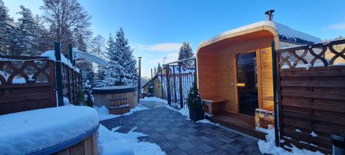 a wooden cabin in the snow with a deck at Penzion na Lůkách in Horní Bečva
